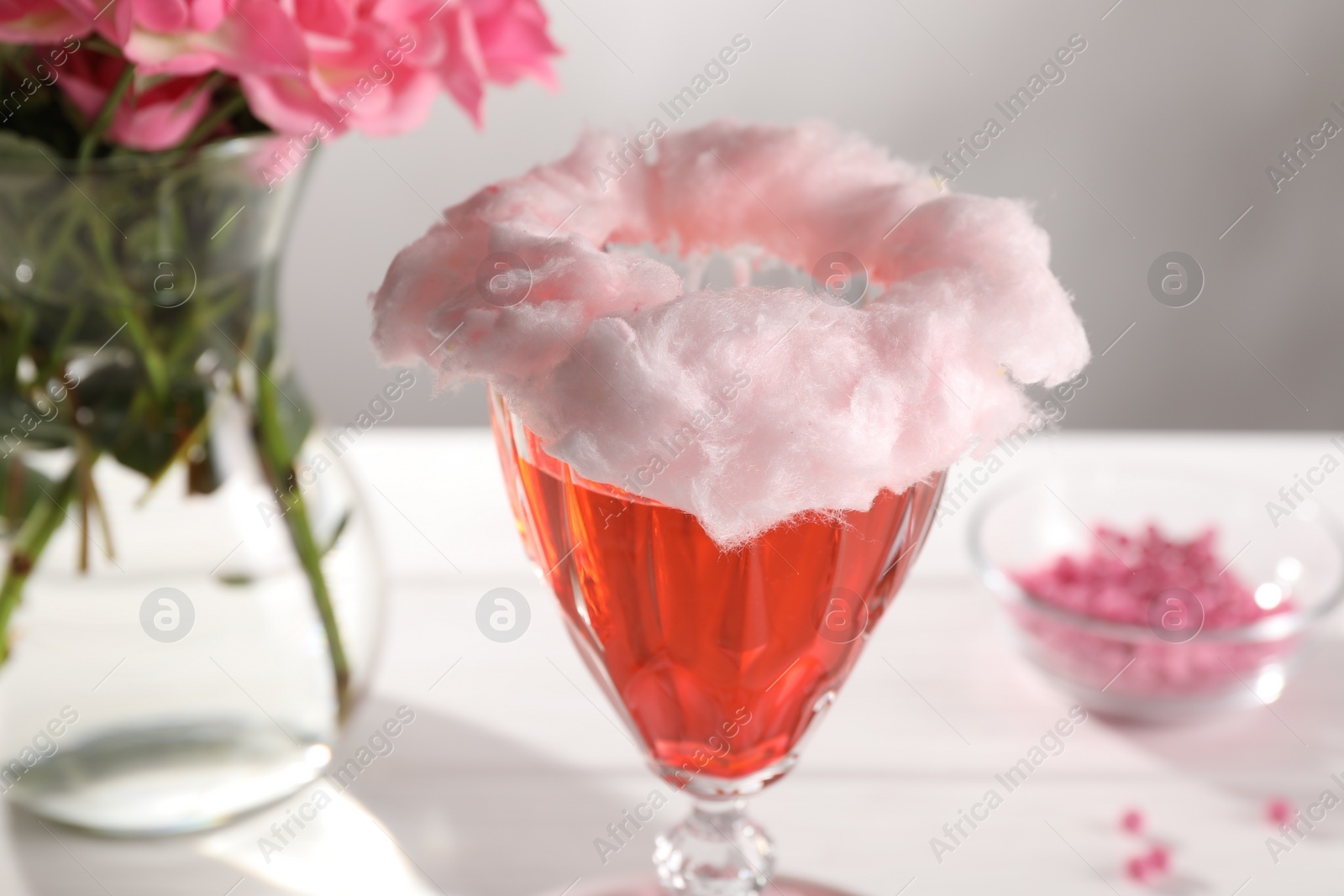 Photo of Cotton candy cocktail in glass on white table, closeup