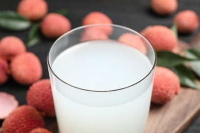 Glass of fresh lychee juice on table, closeup