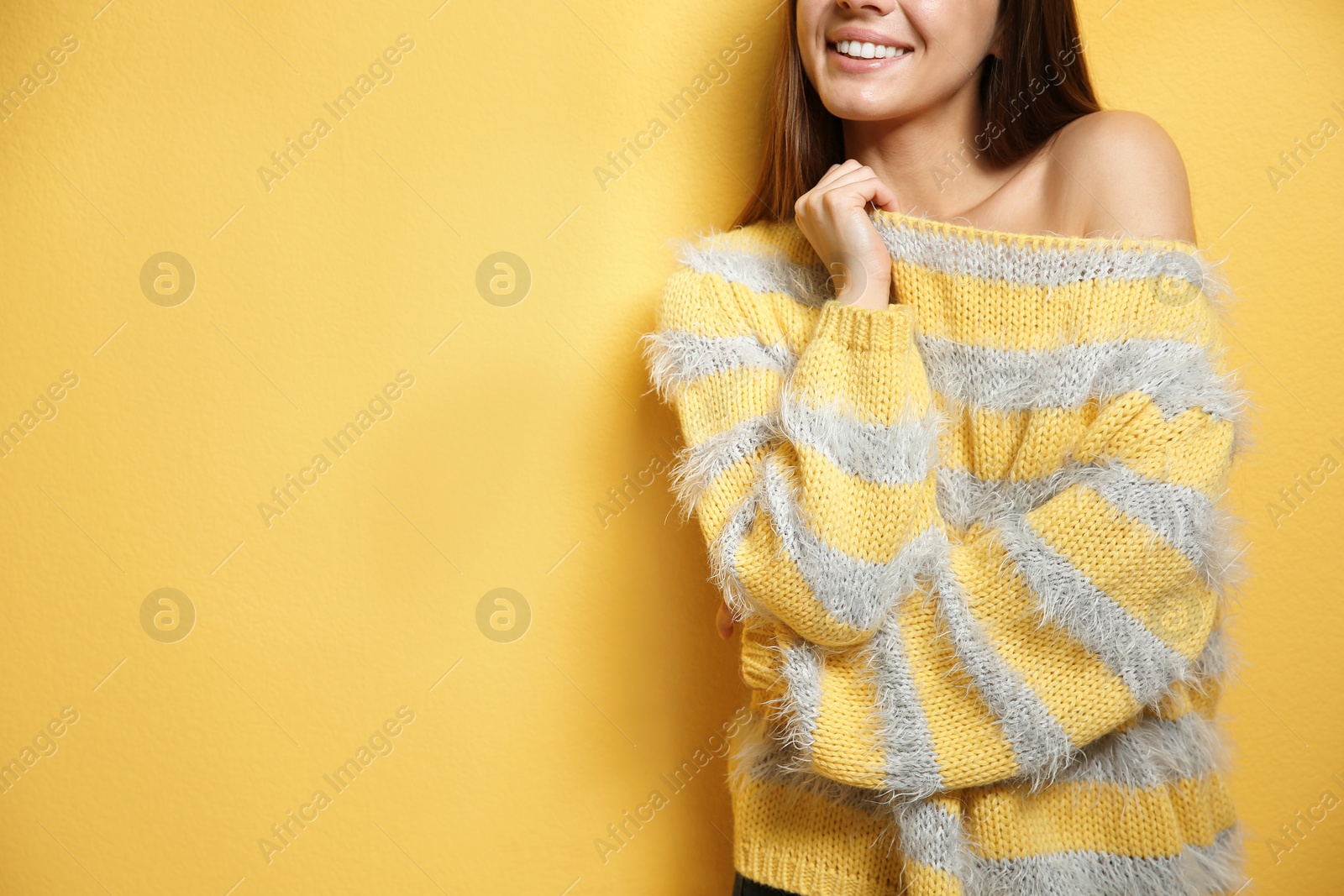 Photo of Beautiful young woman in warm sweater on color background. Space for text