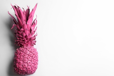 Painted pink pineapple on white background, top view. Creative concept