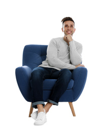 Handsome young man sitting in armchair on white background