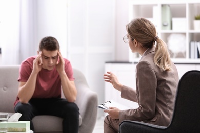 Psychotherapist working with young man in office