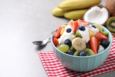 Delicious fruit salad on grey table. Space for text