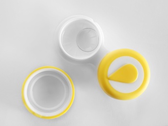 Photo of Container with contact lenses on white background