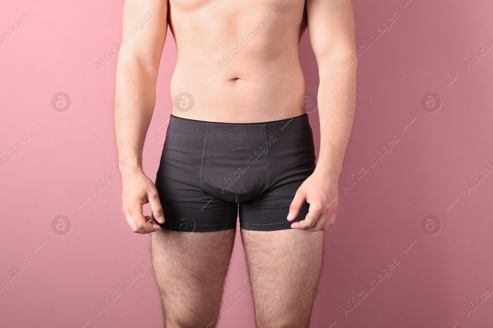 Photo of Attractive young man in underwear on color background