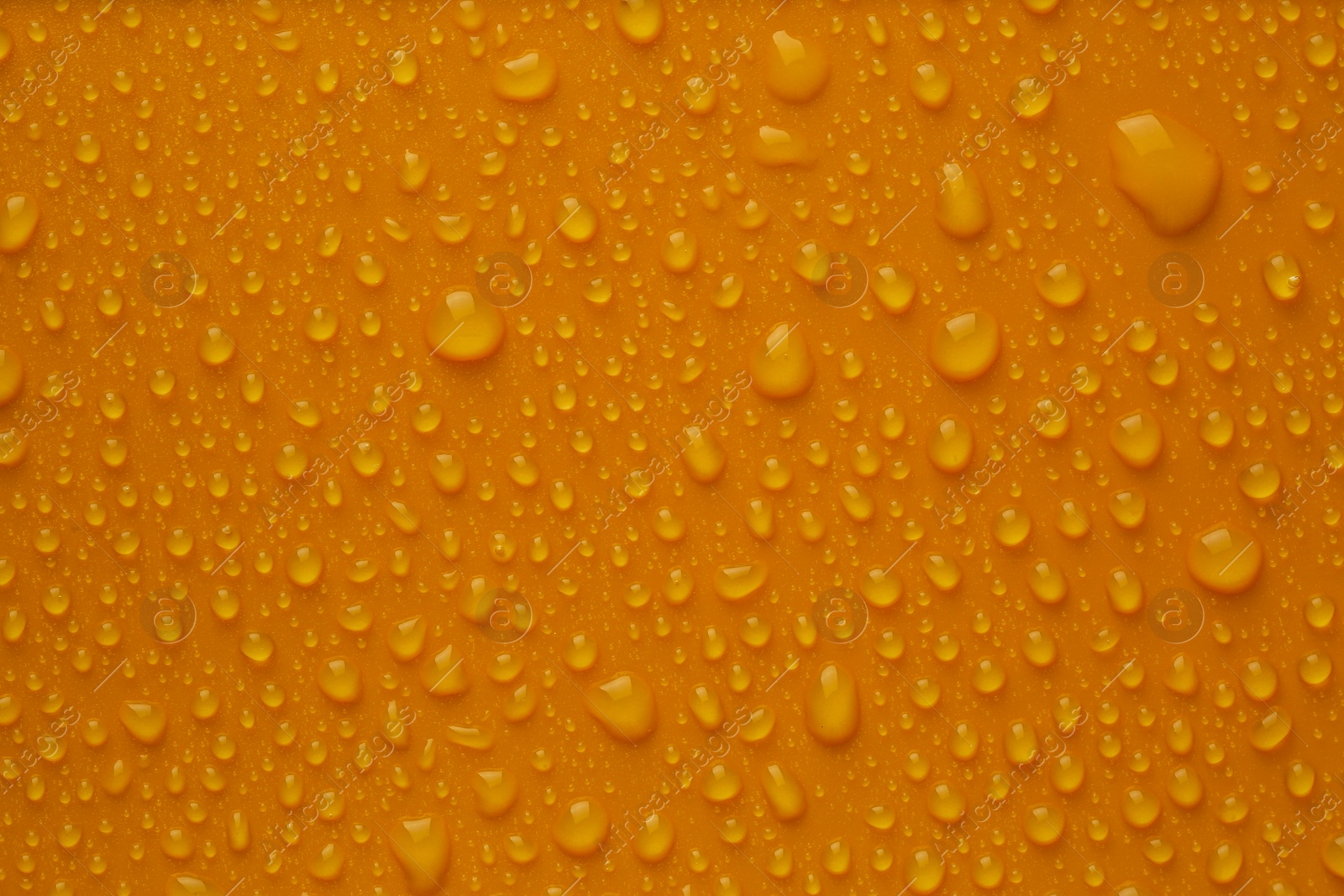 Photo of Many water drops on bright orange background
