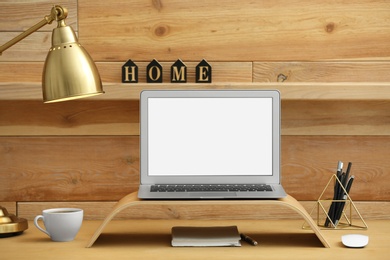 Photo of Modern laptop on desk in room. Home workplace