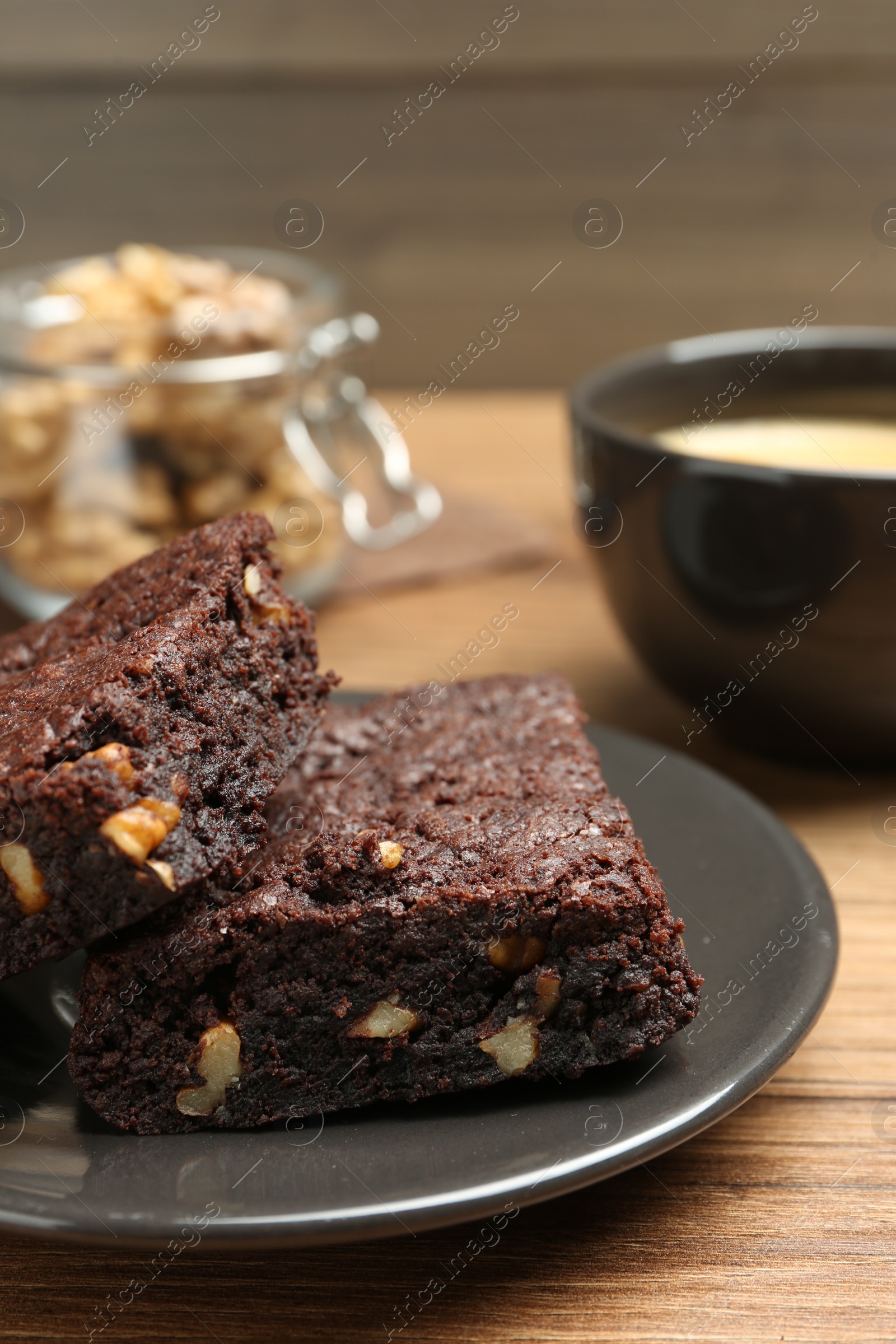 Photo of Delicious chocolate brownies with nuts on wooden table, closeup
