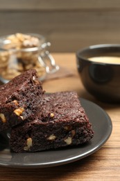 Delicious chocolate brownies with nuts on wooden table, closeup