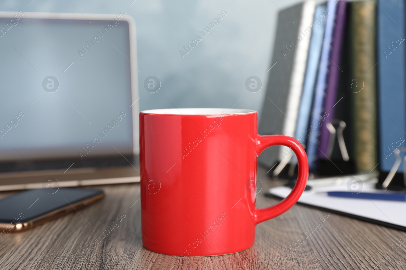 Photo of Coffee Break at workplace. Cup of hot drink on wooden table