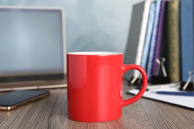 Photo of Coffee Break at workplace. Cup of hot drink on wooden table