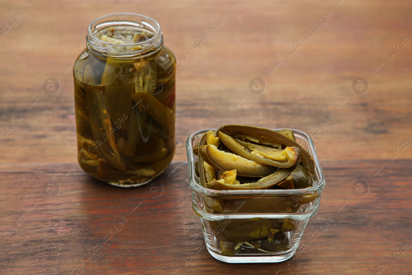 Photo of Pickled green jalapeno peppers on wooden table