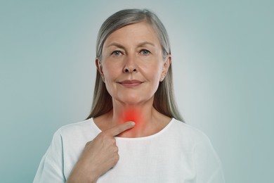 Image of Endocrine system. Woman doing thyroid self examination on light blue background