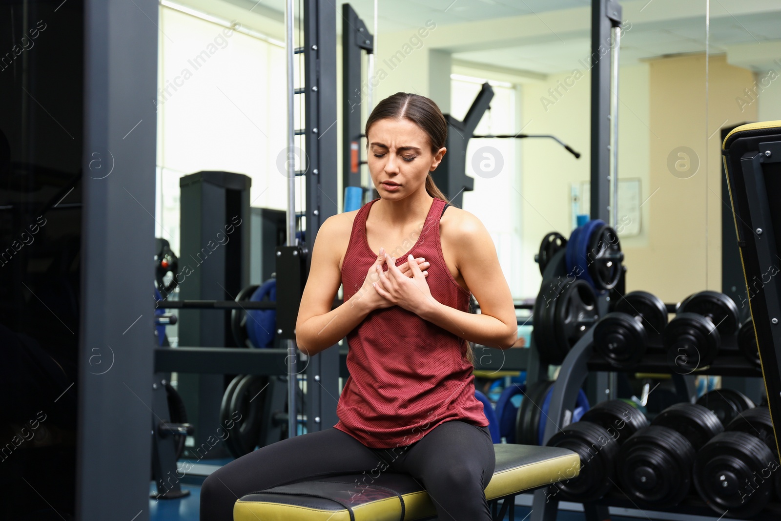 Photo of Young woman having heart attack in gym