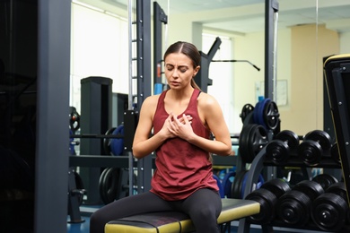 Young woman having heart attack in gym