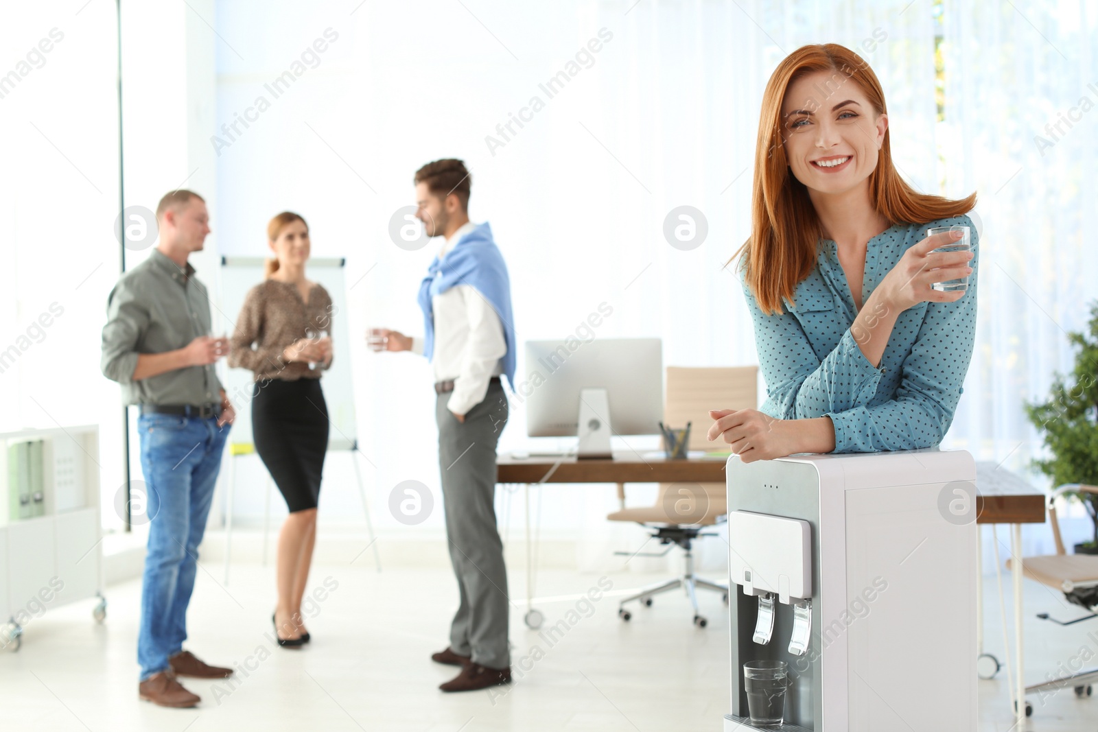 Photo of Portrait of office employee with glass near water cooler at workplace. Space for text