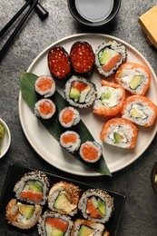 Flat lay composition with delicious sushi rolls on dark grey table