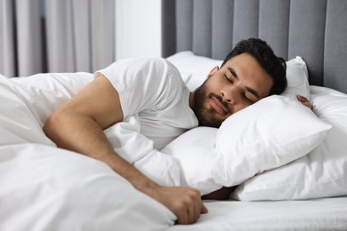 Handsome man sleeping in bed at morning