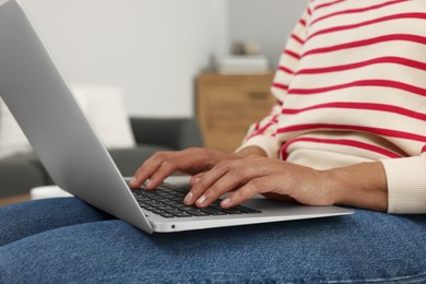 Photo of Woman using laptop in room, closeup view