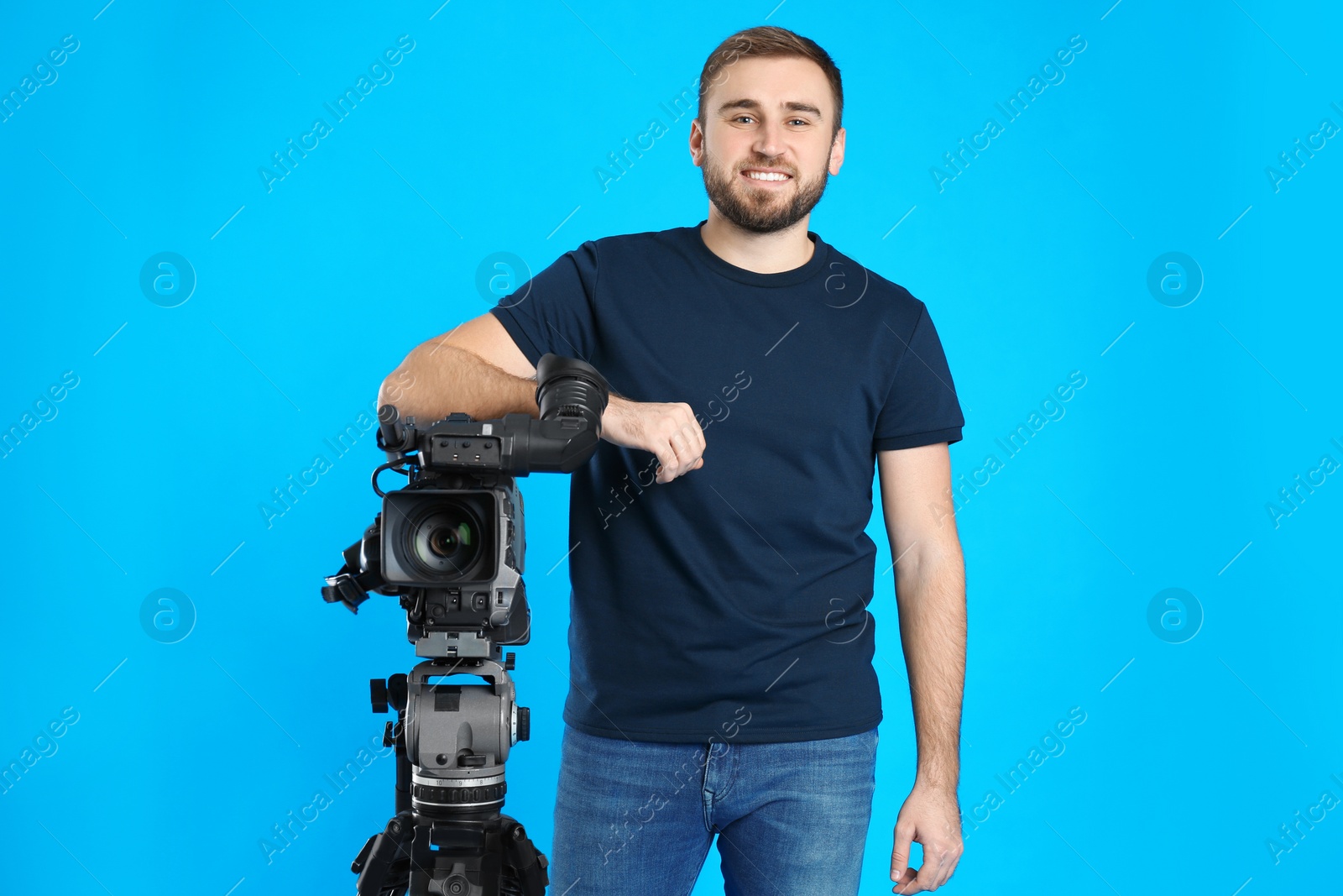 Photo of Operator with professional video camera on blue background