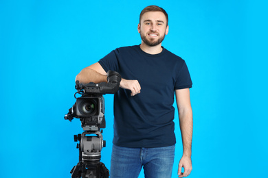 Photo of Operator with professional video camera on blue background