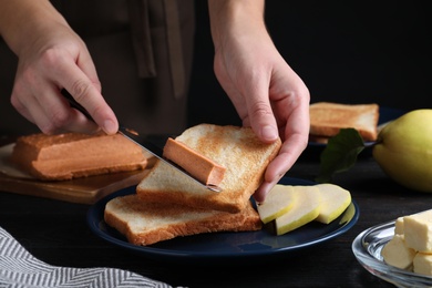 Photo of Woman making sandwich with quince paste at table, closeup