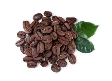 Photo of Pile of roasted coffee beans with fresh leaves on white background, top view