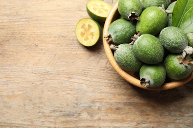 Flat lay composition with fresh green feijoa fruits on wooden table, space for text