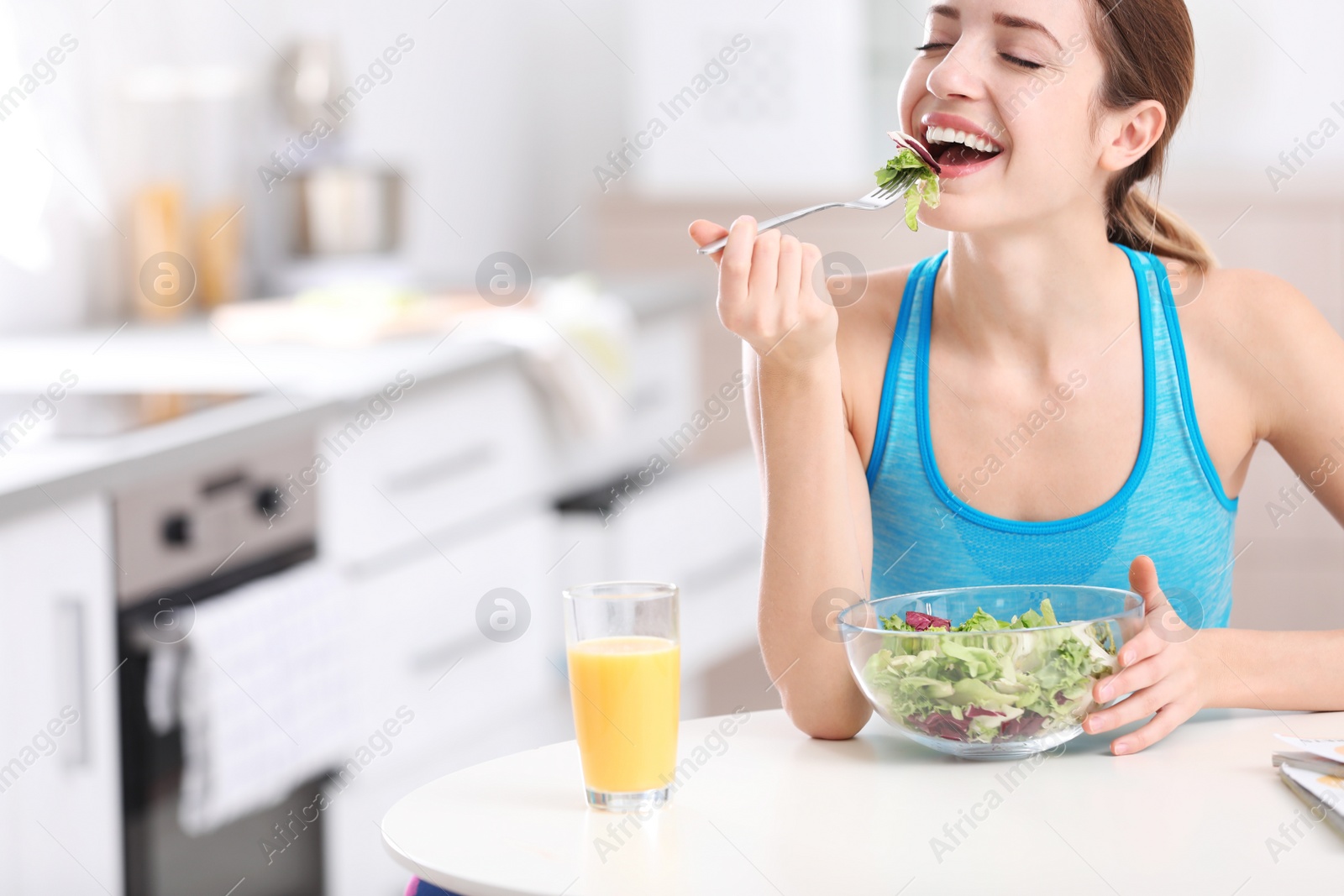 Photo of Young woman in fitness clothes having healthy breakfast at home. Space for text