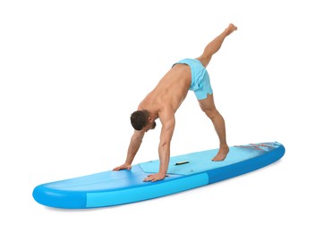 Handsome man practicing yoga on blue SUP board against white background