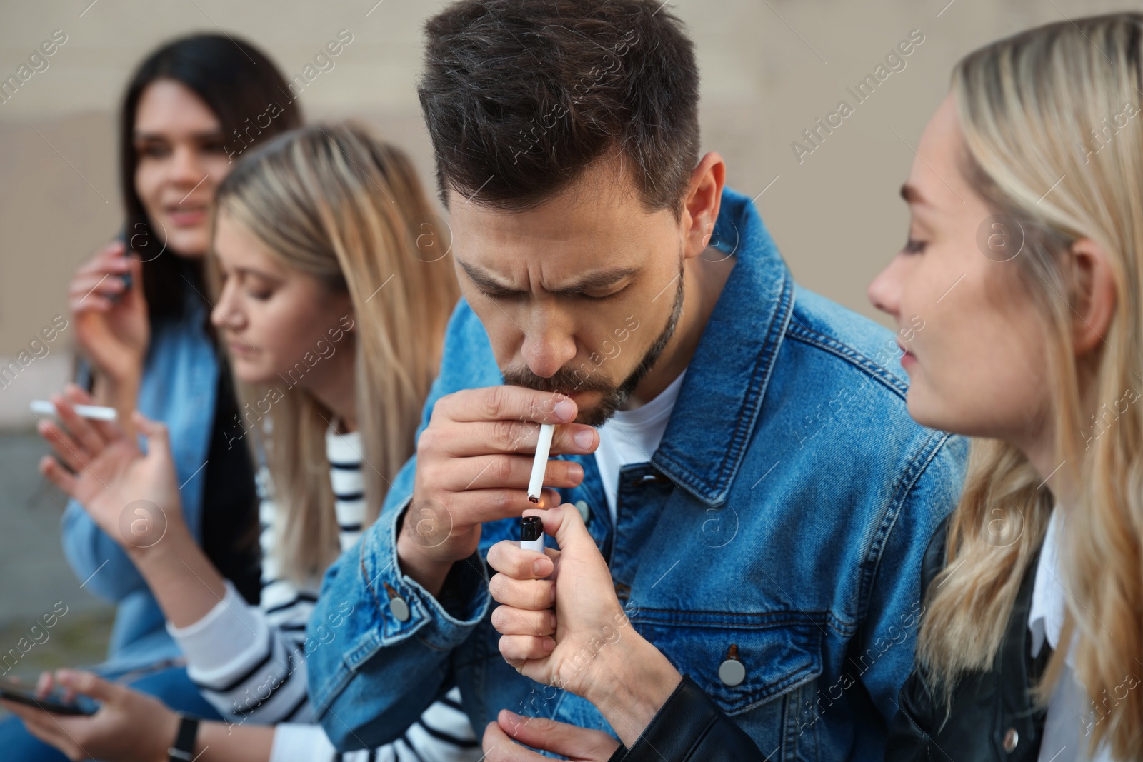 Photo of People smoking cigarettes at public place outdoors