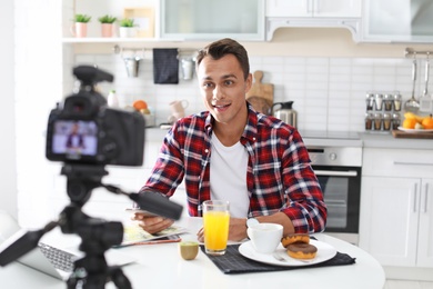 Food blogger recording video on camera in kitchen