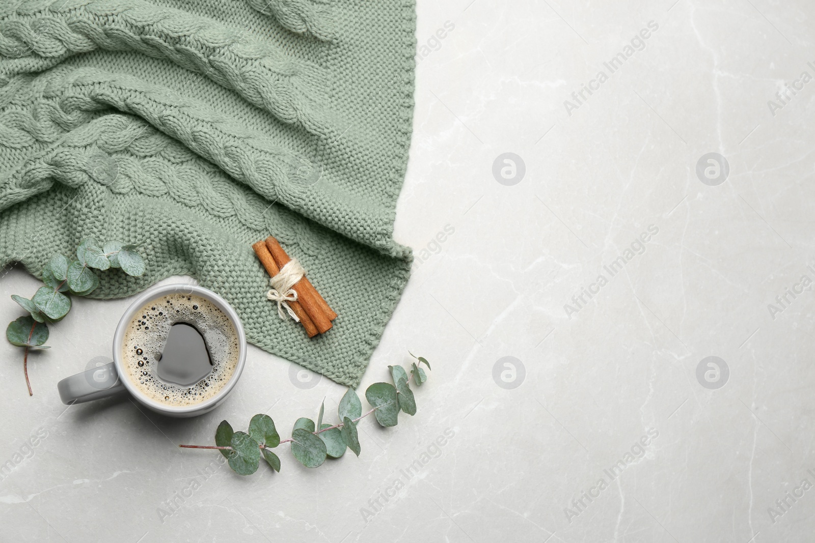 Photo of Flat lay composition with hot drink and warm plaid on light marble table, space for text