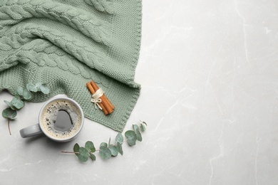 Photo of Flat lay composition with hot drink and warm plaid on light marble table, space for text