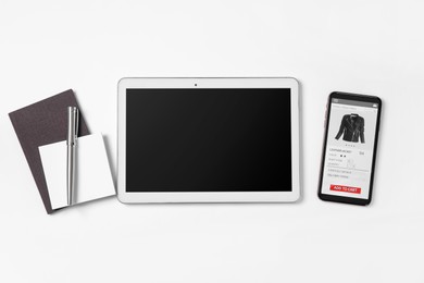 Online store. Tablet, smartphone and stationery on. white background, flat lay
