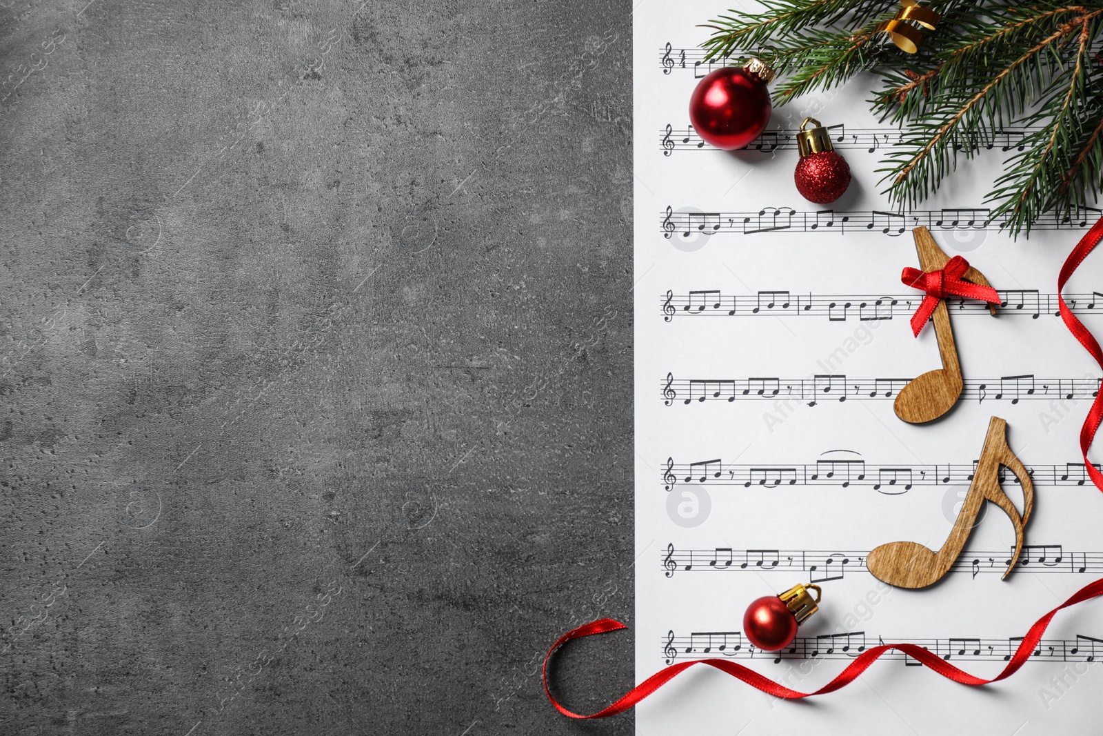 Photo of Christmas decorations, notes and music sheet on grey stone table, flat lay with space for text