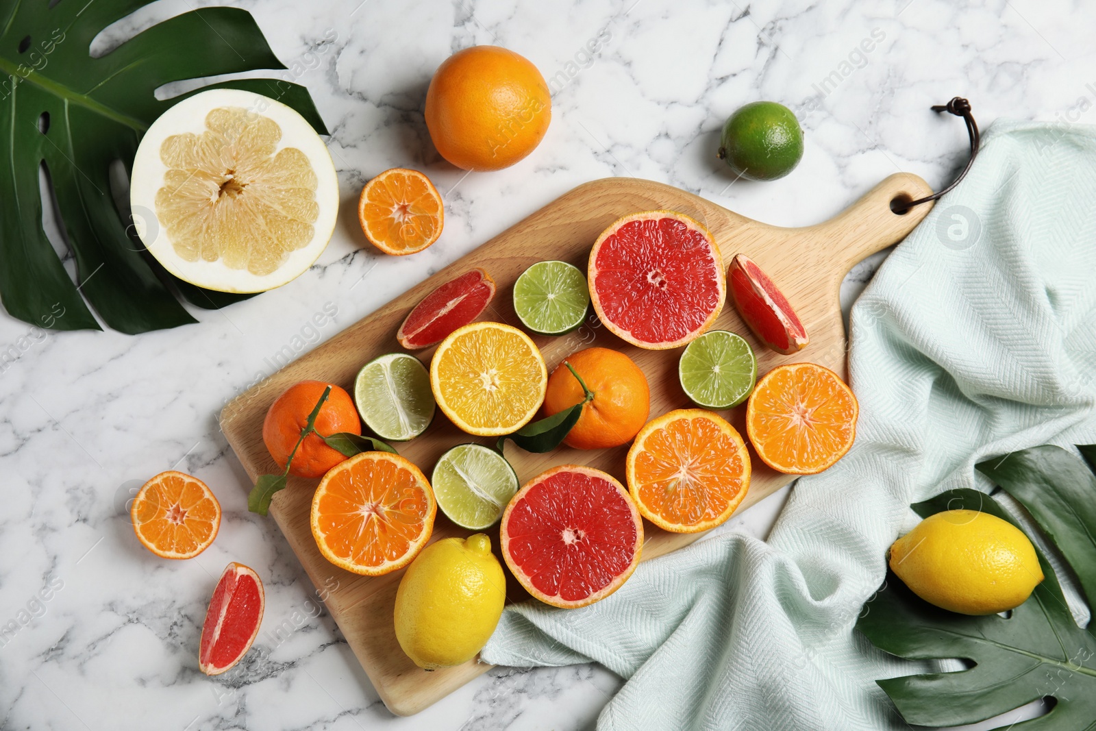 Photo of Different citrus fruits on marble background, top view