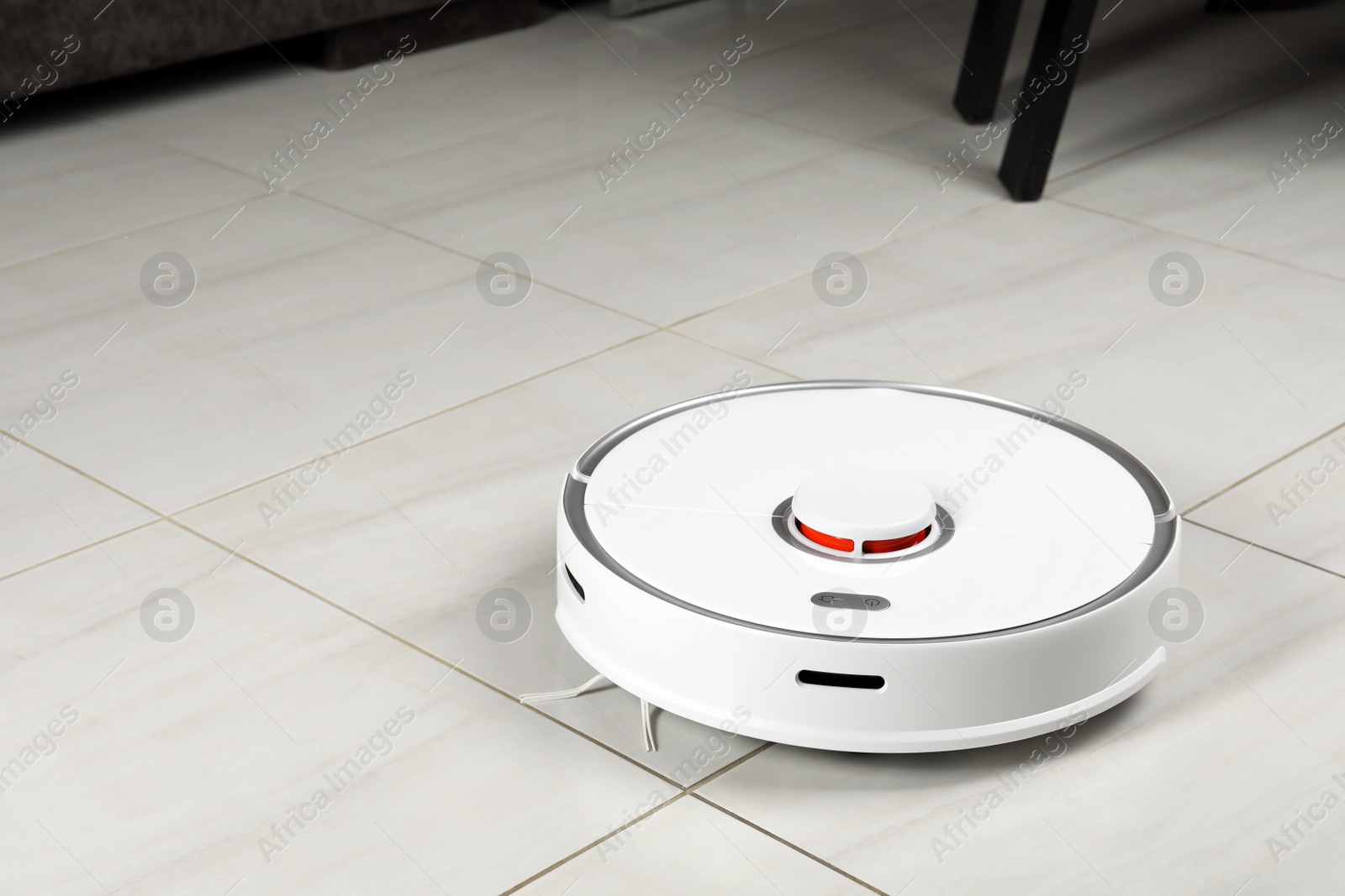 Photo of Robotic vacuum cleaner on white tiled floor indoors, space for text