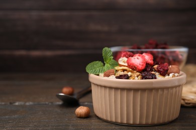 Photo of Oatmeal with freeze dried fruits, nuts and mint on wooden table, closeup. Space for text