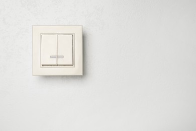 Photo of Modern light switch on white background. Space for text