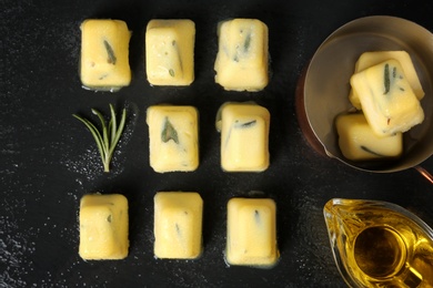 Flat lay composition with rosemary and olive oil ice cubes on dark background