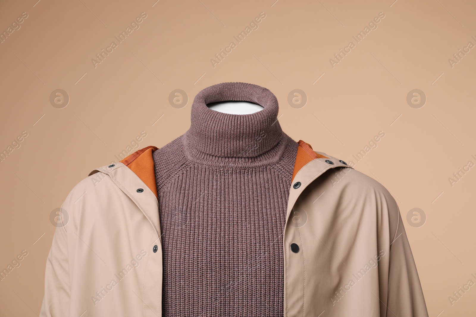 Photo of Male mannequin dressed in stylish coat and turtleneck on beige background