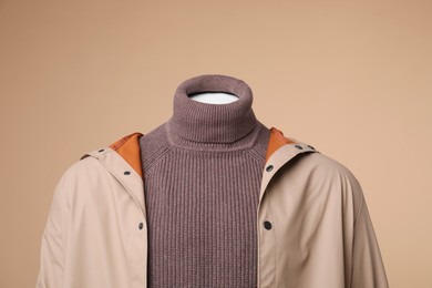 Photo of Male mannequin dressed in stylish coat and turtleneck on beige background