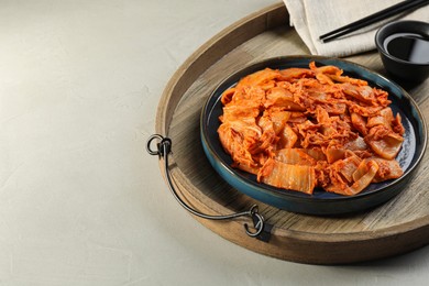 Photo of Delicious kimchi with Chinese cabbage and sauce on light grey table, space for text