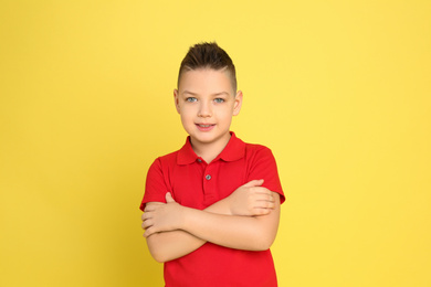 Photo of Portrait of cute little boy on yellow background