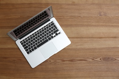 Modern laptop on wooden table, top view