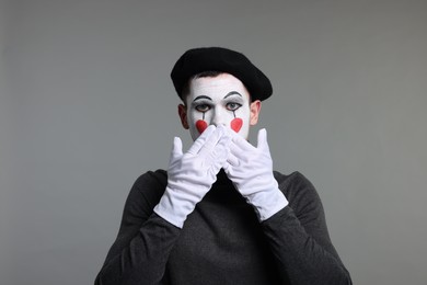 Photo of Mime artist in beret posing on grey background