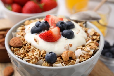 Photo of Tasty granola, yogurt and fresh berries in bowl, closeup. Healthy breakfast