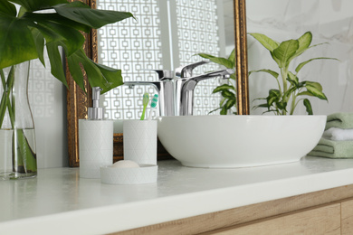 Toiletries and sink near vintage mirror in bathroom