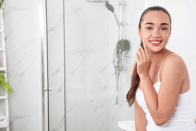 Photo of Beautiful young woman with perfect skin in bathroom, space for text. Facial wash